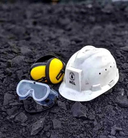 Mine safety helmet, goggles and ear protection on coal